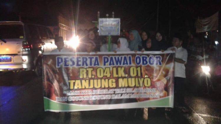 Diguyur Hujan Warga Kampung Baru Tembesi Tetap Semangat Ikuti Pawai Obor 